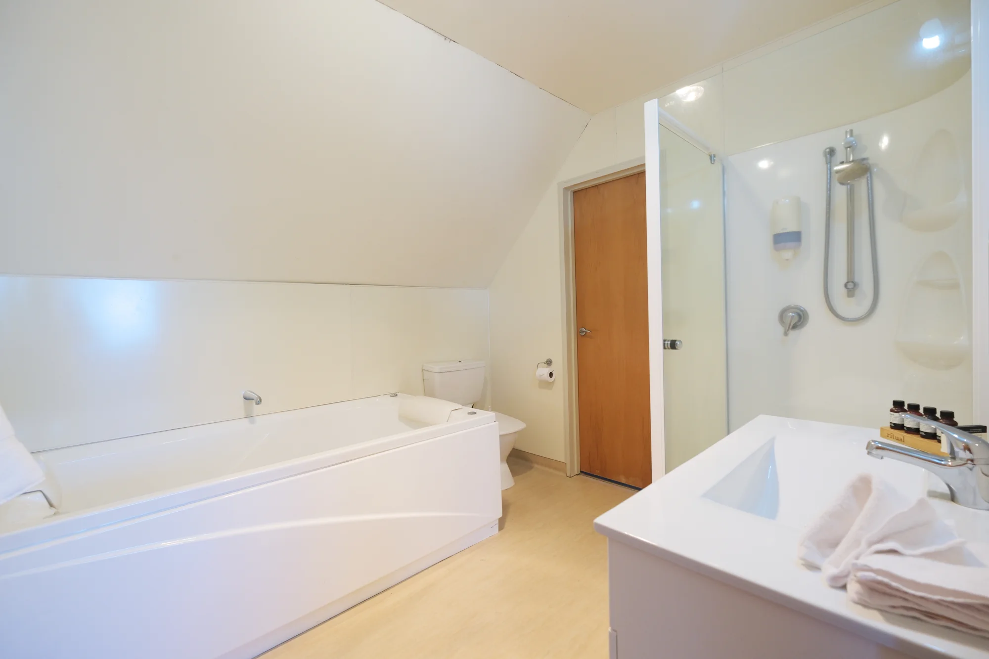 Bathroom with a bath and separate shower at Twin Peaks Lakeside Inn, Taupō